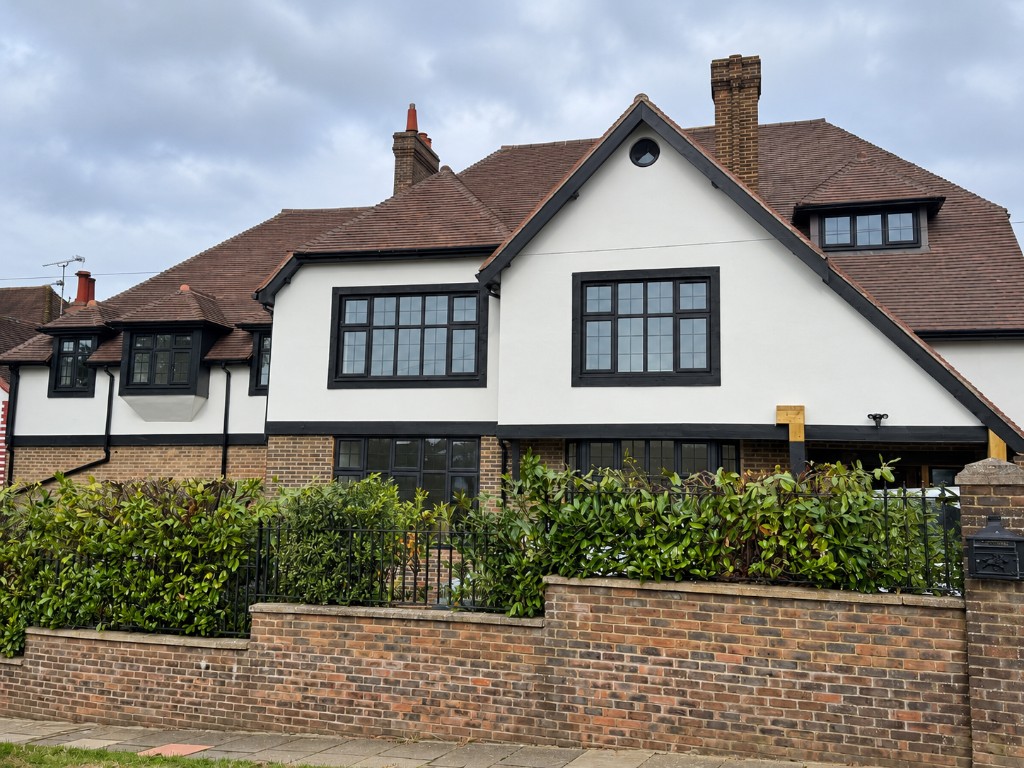 White house with black grid-style windows across the front and dormers