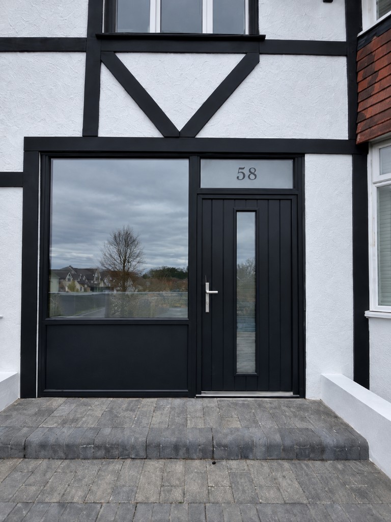 Black front door with large side window and house number 58 in the transom