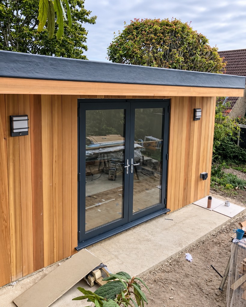 Anthracite French doors on a timber-clad garden building